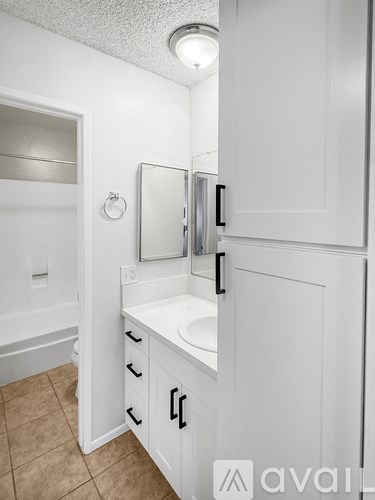 A white bathroom with a sink and a mirror.