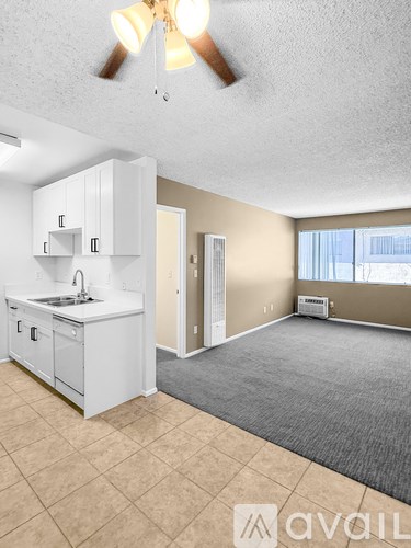 A kitchen with white cabinets and a ceiling fan.