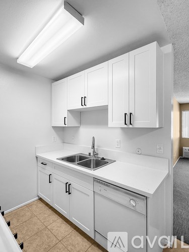 A kitchen with white cabinets and a sink.