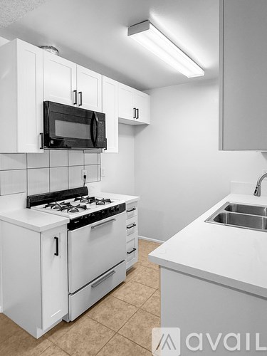 A kitchen with white cabinets and appliances.