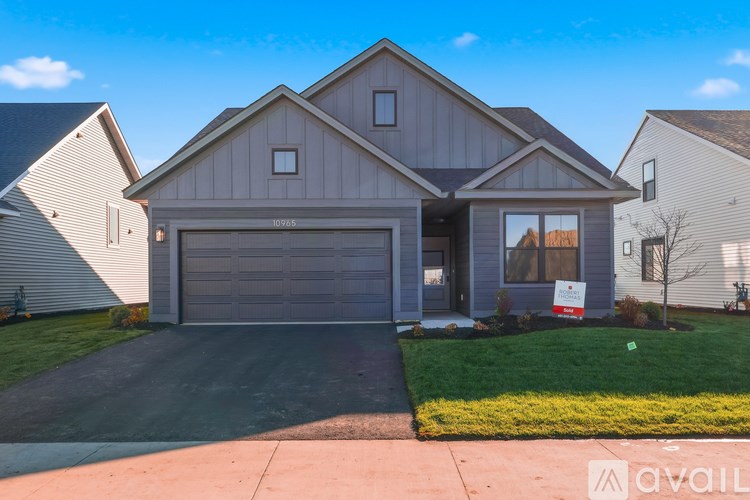 A house with a garage and a driveway in front of it.