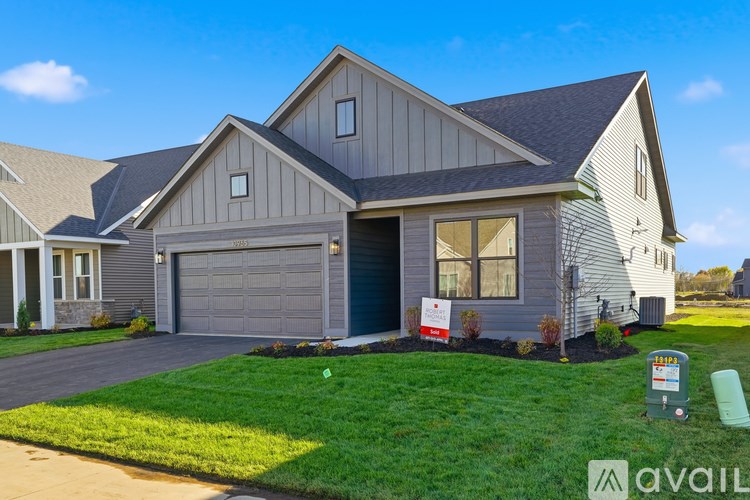A house with a garage and a sign in front of it.