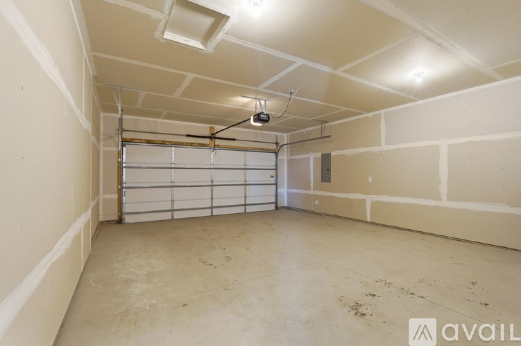 A spacious garage with a white ceiling and a closed white door.
