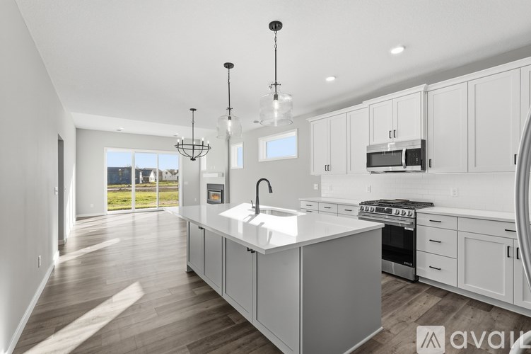 A modern kitchen with a large island and a view of the outdoors.