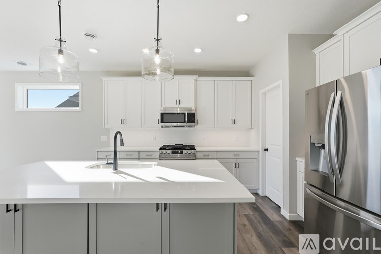 A modern kitchen with a stainless steel refrigerator and white countertops.