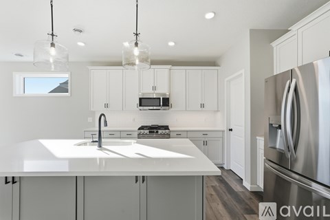 A modern kitchen with a stainless steel refrigerator and white countertops.