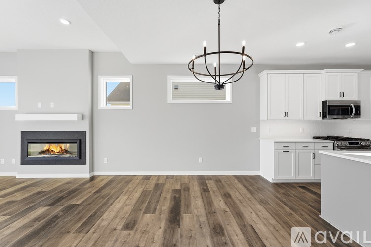 A modern kitchen with a wood floor and a fireplace.