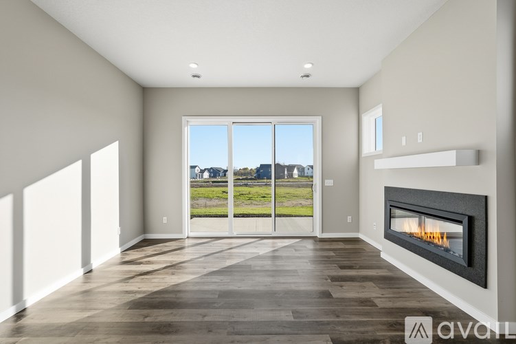 A modern living room with a fireplace and large windows.