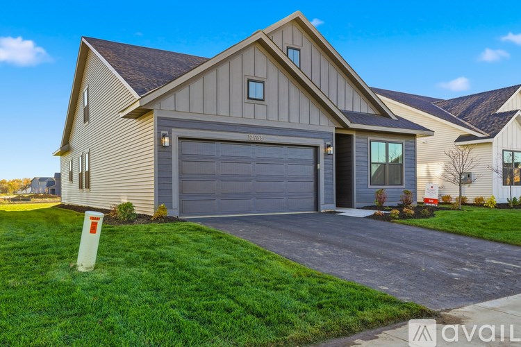 A house with a garage and a driveway in front of it.