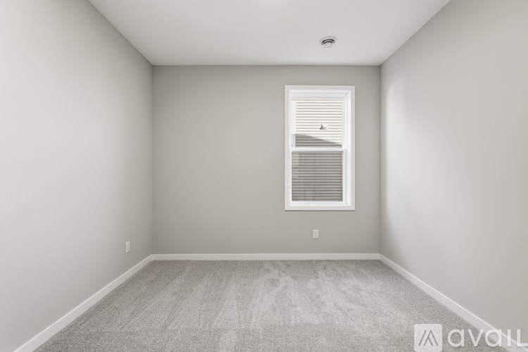 A room with a window and carpeted floor.