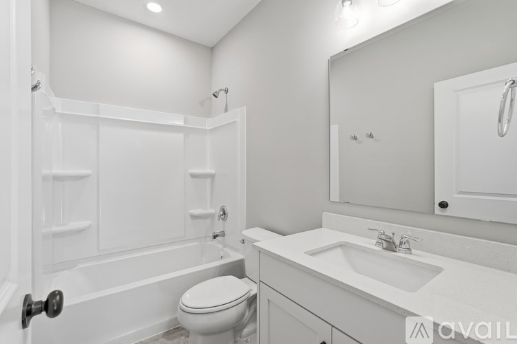 A white bathroom with a toilet, sink, and bathtub.