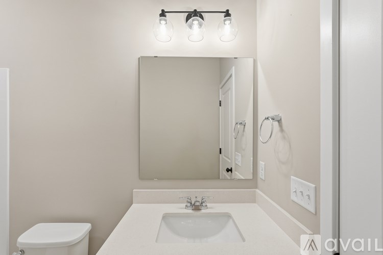 A bathroom with a white sink and a white toilet.