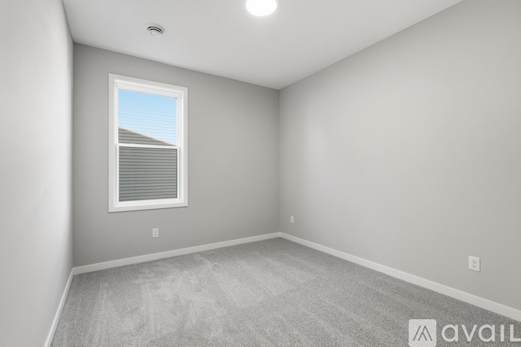 A room with a window and carpeted floor.