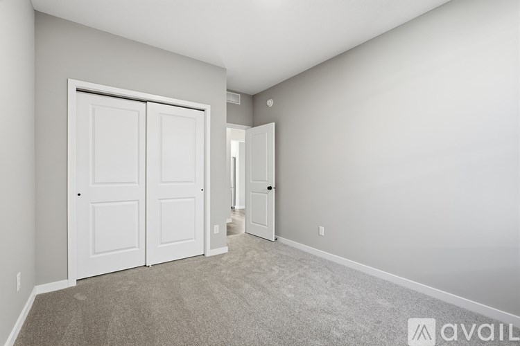 A room with a carpeted floor and two white doors.