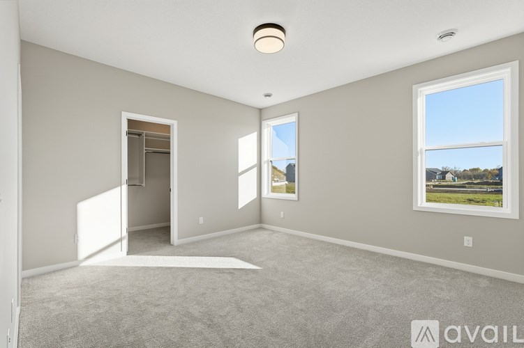 A spacious room with a carpeted floor and a large window overlooking a landscape.