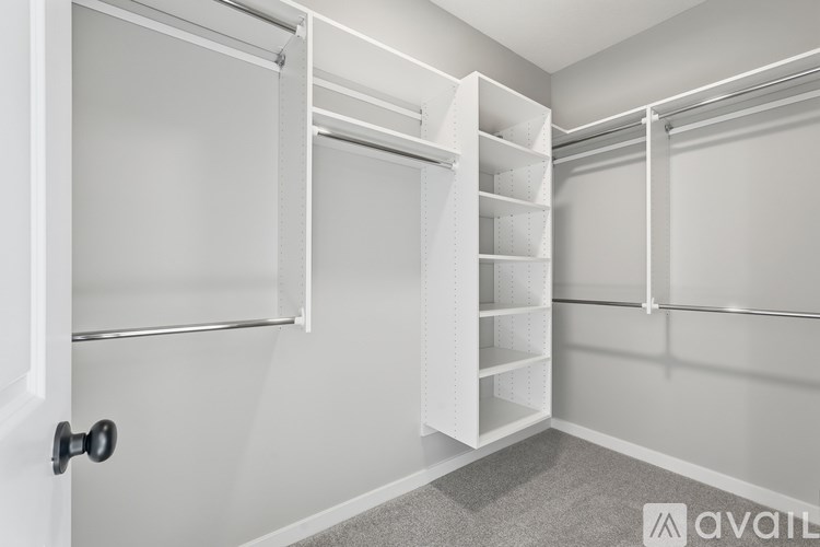 A white closet with shelves and a door.