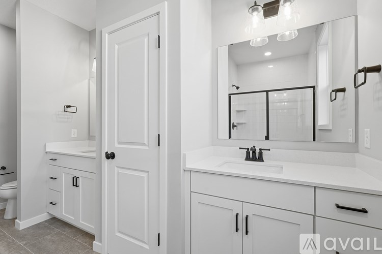 A bathroom with a white sink and a white toilet.