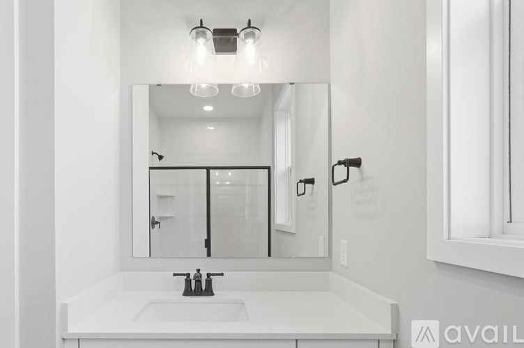 A bathroom with a white sink and a mirror above it.