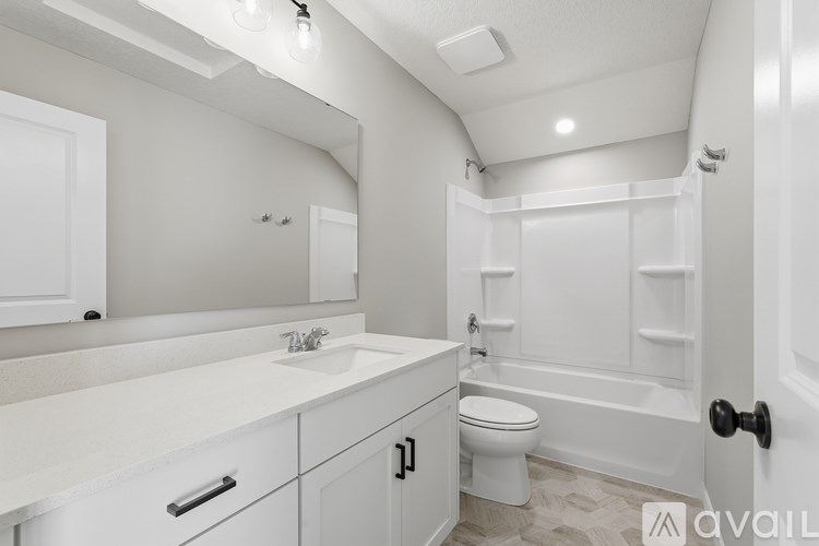 A white bathroom with a toilet, sink, and bathtub.