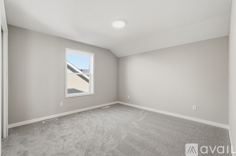 A room with a window and carpeted floor.