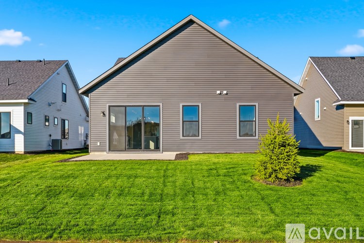 A house with a brown roof and a green lawn in front.