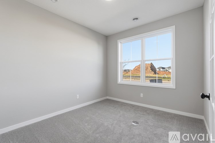 A room with a large window overlooking a residential area.
