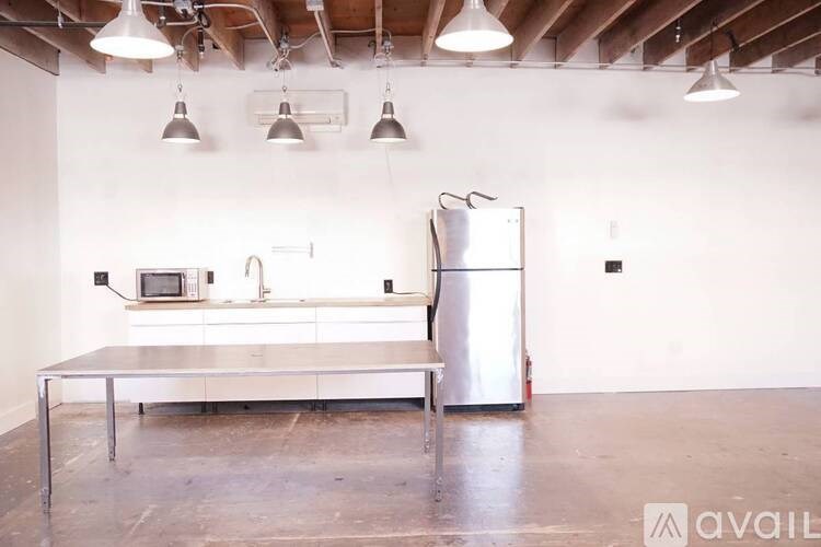 A kitchen with a stainless steel refrigerator, microwave, and a table.