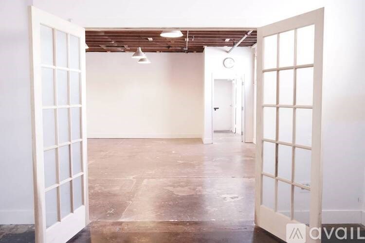 A room with a white door and a wooden ceiling.