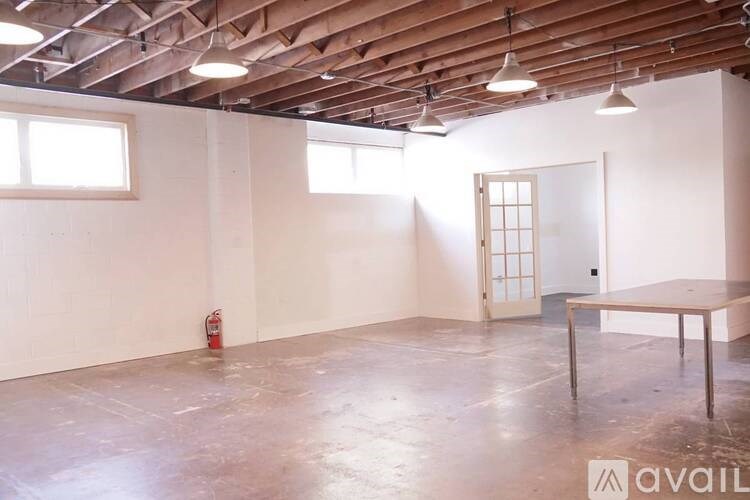 A room with a wooden ceiling and a fire extinguisher on the floor.