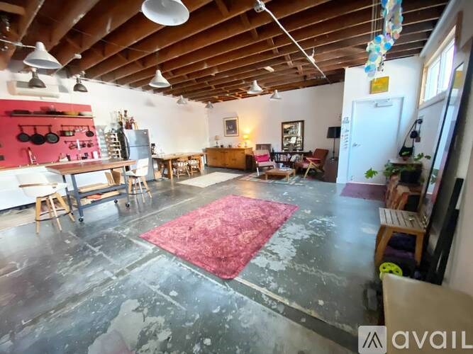 A room with a wooden ceiling and a red rug on the floor.