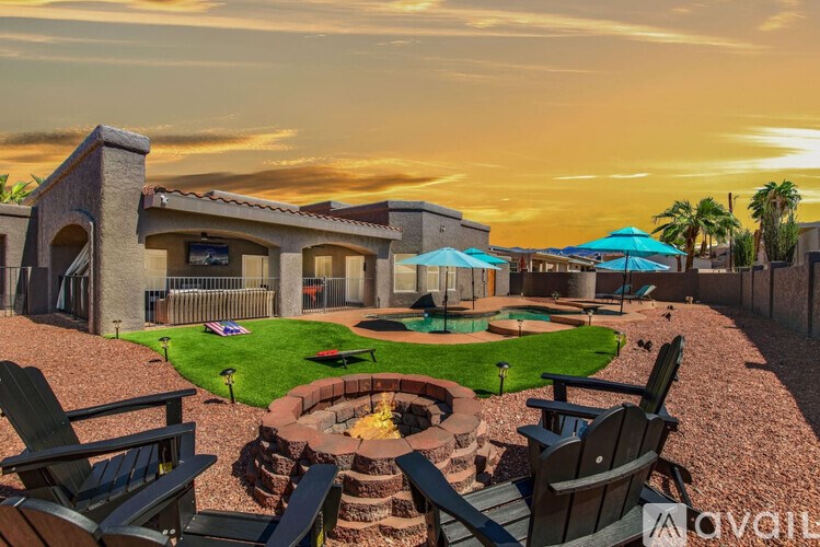 A backyard with a fire pit and chairs.