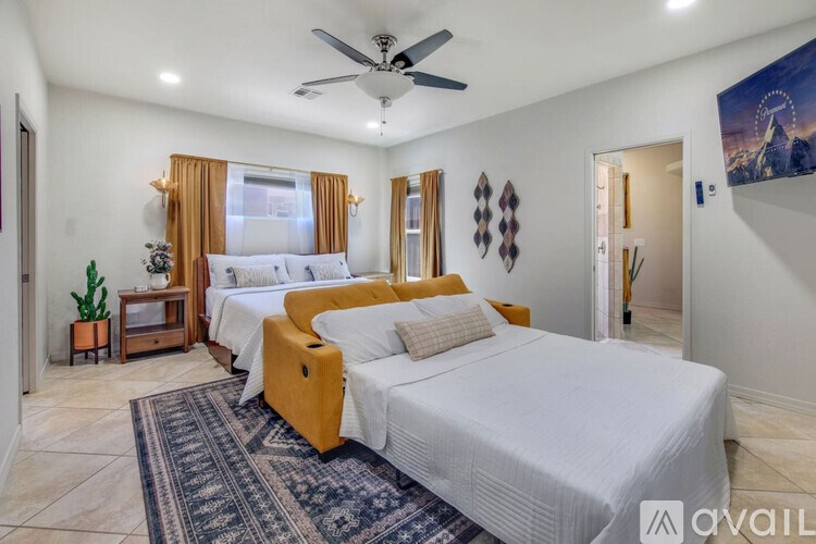 A bedroom with two beds and a ceiling fan.