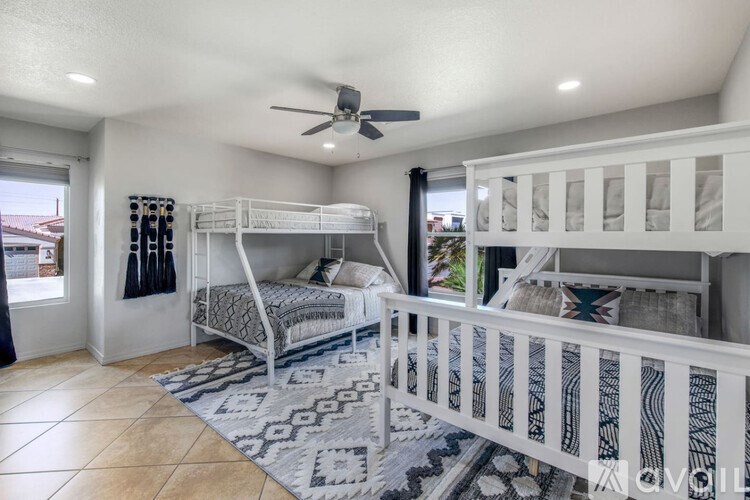 A room with two bunk beds and a rug.