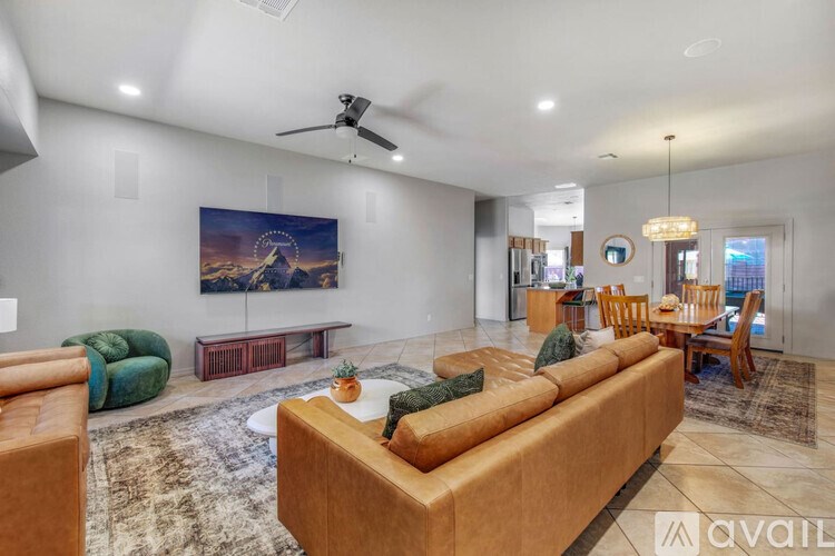 A living room with a large couch and a painting on the wall.