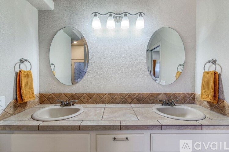A bathroom with two sinks and two mirrors.