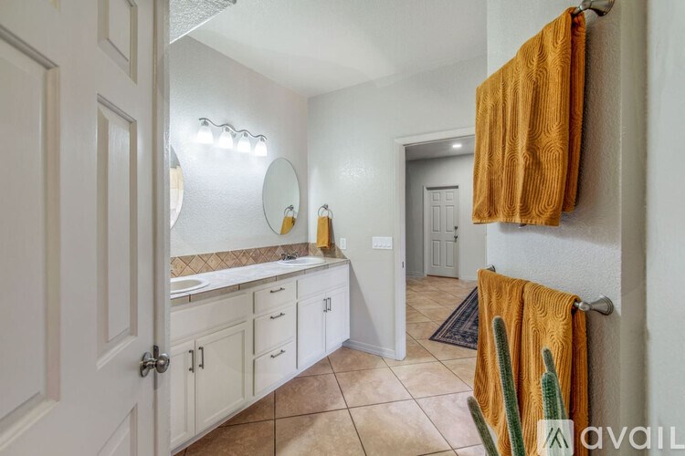 A bathroom with a white vanity and a mirror above it.