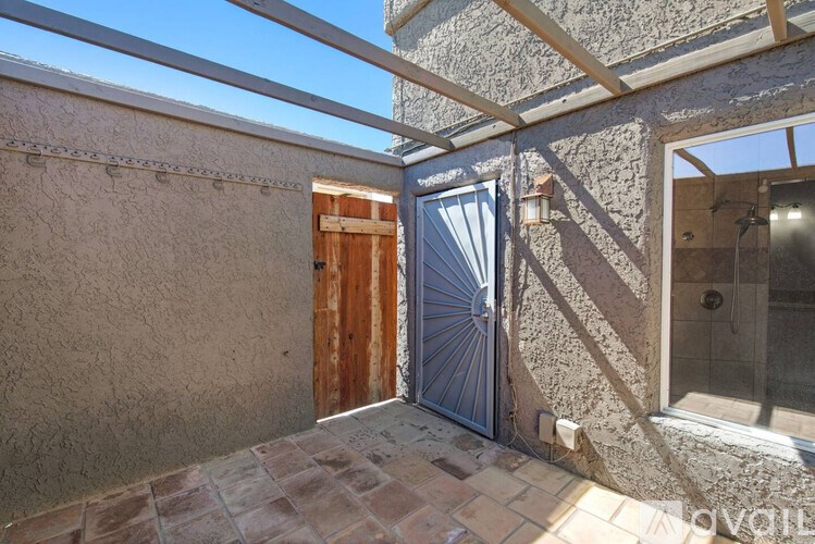 A patio area with a door and a wall.