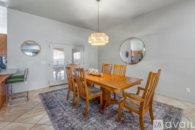 A dining room with a wooden table and chairs.