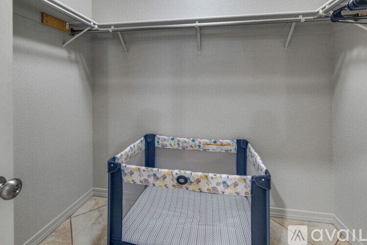 A baby crib with a floral pattern is set up in a room.