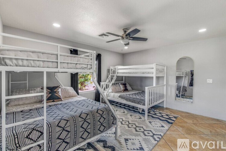 A room with white walls and a ceiling fan is shown.