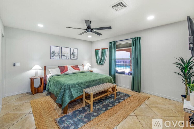 A bedroom with a bed, a bench, and a ceiling fan.