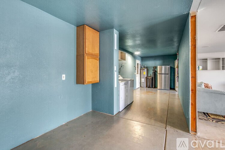 A kitchen area with a blue wall and a white fridge.
