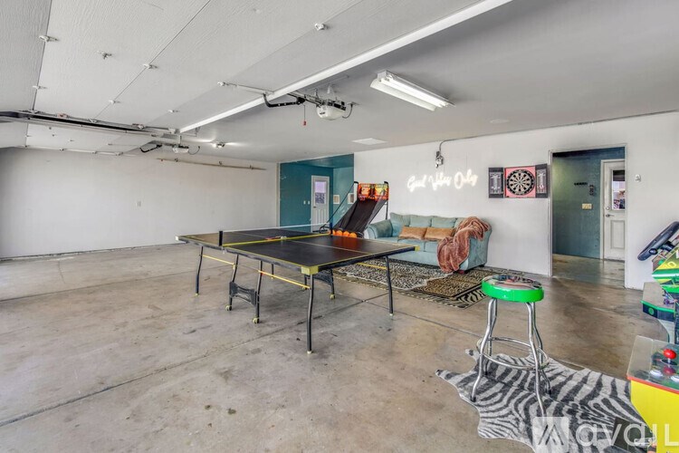A room with a ping pong table and a dartboard on the wall.