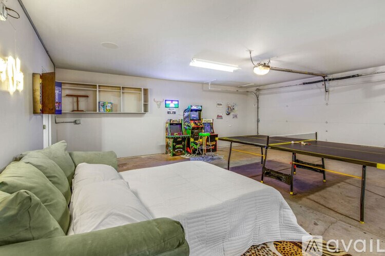 A room with a green couch and a white bedspread.