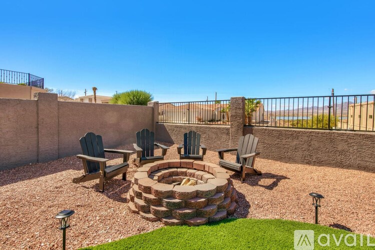 A backyard with a fire pit and chairs.