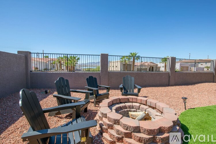 A patio with chairs and a fire pit.