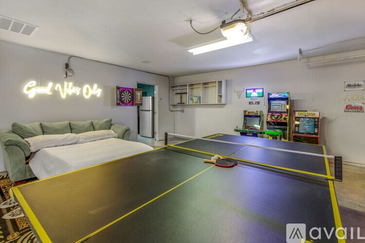 A room with a ping pong table and a couch.