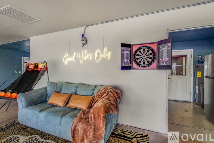 A room with a neon sign that says "Good Vibes Only" on the wall.