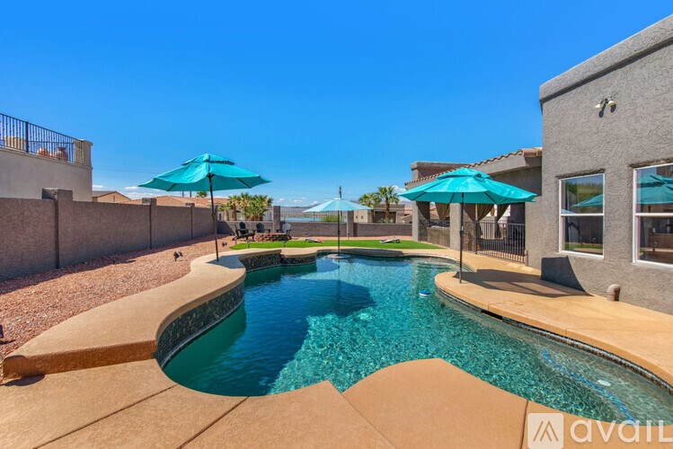 A swimming pool with a slide and a house in the background.