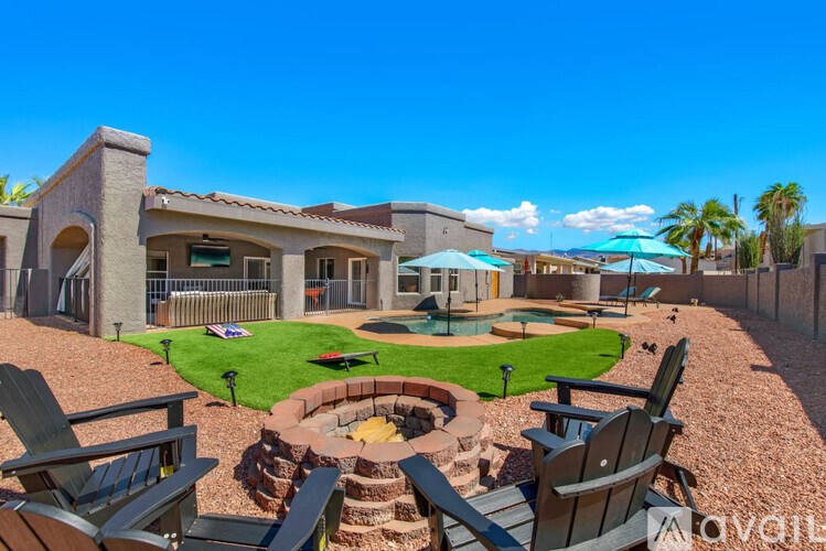 A backyard with a fire pit and chairs.